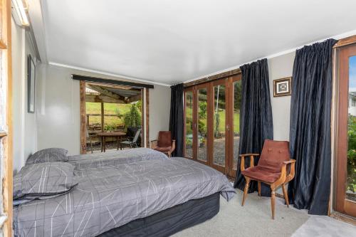 - une chambre avec un lit et une grande fenêtre dans l'établissement 39 North - Tutukaka Holiday Home, à Tutukaka