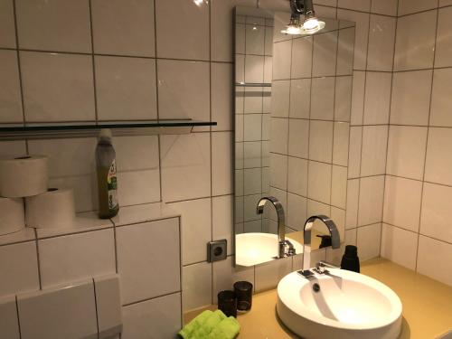 een witte badkamer met een wastafel en een spiegel bij Lochau Sonnenuntergang genießen in Lochau