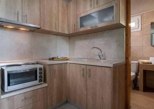 a kitchen with a microwave and a sink at Malama Rooms in Sikia
