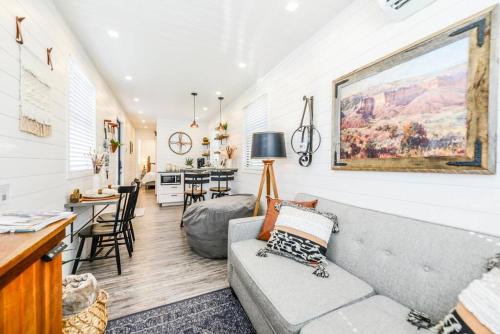 a living room with a gray couch and a kitchen at New Luxury Shipping Container in Bellmead
