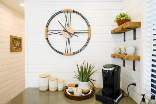 a clock hanging on a wall with a coffee maker at New Luxury Shipping Container in Bellmead