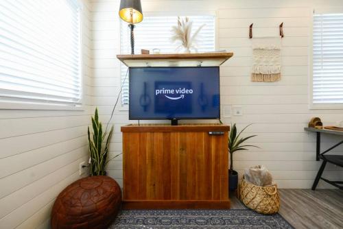 a television sitting on a wooden stand in a room at New Luxury Shipping Container in Bellmead