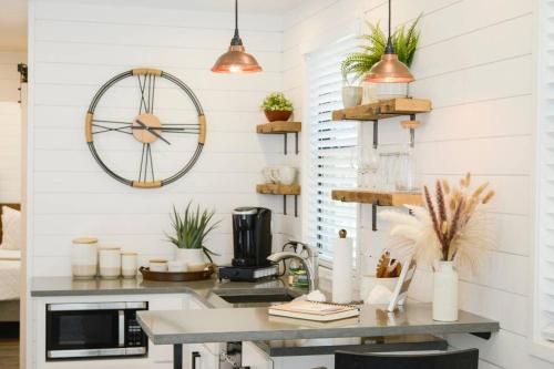 a kitchen with a table and a clock on the wall at New Luxury Shipping Container in Bellmead