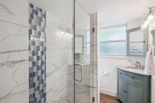 een badkamer met een glazen douche en een wastafel bij Beach Livin 1 - 1 Bedroom Downstairs in St Pete Beach