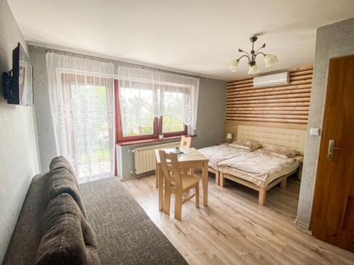 a bedroom with a bed and a table and a couch at Pokoje gościnne Anna in Milicz