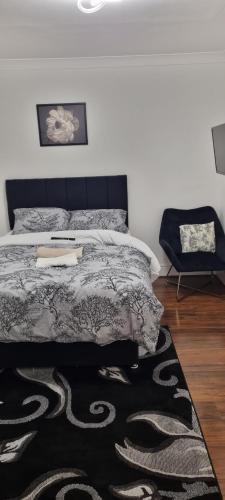 a bedroom with a bed and a chair and a rug at Nikoda Lodge in Gillingham