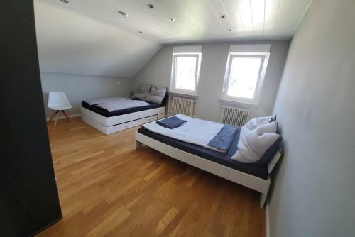 een slaapkamer met 2 bedden en 2 ramen bij 100 qm DG Wohnung 《Kehr wieder》Bexbach Saarland in Bexbach