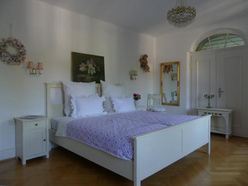 1 dormitorio con 1 cama grande y edredón morado en B&B Rosenliebe, en Niedereschach
