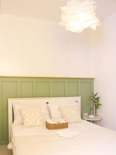 a bedroom with a white bed with a green wall at Urban Oasis Resort, Tarlac in Tarlac