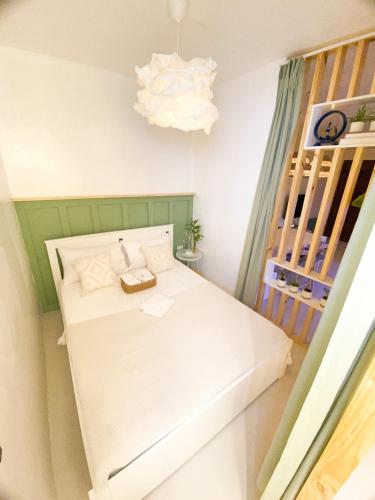 a small room with a white bed and a chandelier at Urban Oasis Resort, Tarlac in Tarlac