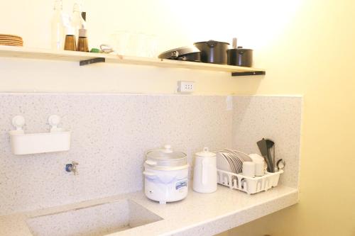 a kitchen counter with some items on a shelf at Urban Oasis Resort, Tarlac in Tarlac