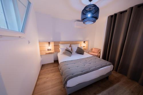 - une petite chambre avec un lit et une lumière bleue dans l'établissement La maison du Port Apt ROMA, à Marseillan