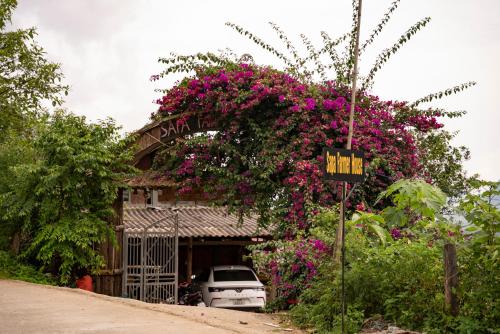 a building with a bunch of pink flowers on it at SaPa Farmer House in Sa Pa