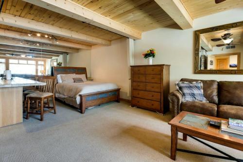 sala de estar con sofá y cama en Ski-InandOut Oversized Aspen Studio with Pool and Hot Tub, en Snowmass Village