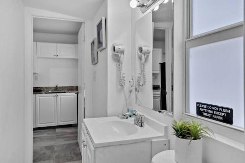 a white bathroom with a sink and a phone at Lovely 1 Bedroom Walking Distance To Ocean - Suite 1 in Hollywood