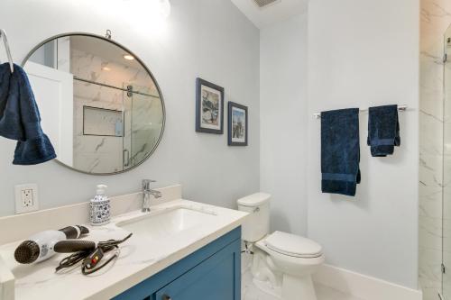 a white bathroom with a sink and a mirror at Oceanfront Galveston Condo in Amazing Location! in Galveston