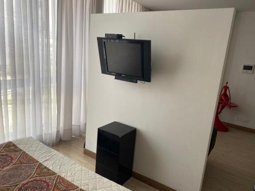 a flat screen tv on a wall in a room at APARTAMENTO TIZIANI MANIZALES in Manizales