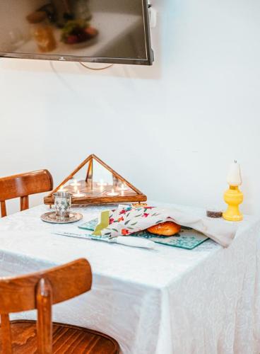 stół z białą tkaniną i lampą w obiekcie Suite Sod HaChaim- Artist Quarter Old City Tzfat w mieście Safed