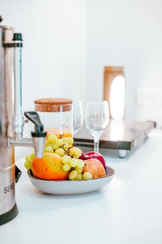 a bowl of fruit on a counter with wine glasses at Suite Sod HaChaim- Artist Quarter Old City Tzfat in Safed