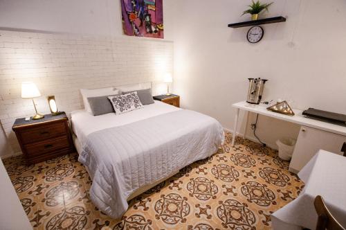 采法特的住宿－Suite Sod HaChaim- Artist Quarter Old City Tzfat，一间卧室配有一张床、一张桌子和闹钟