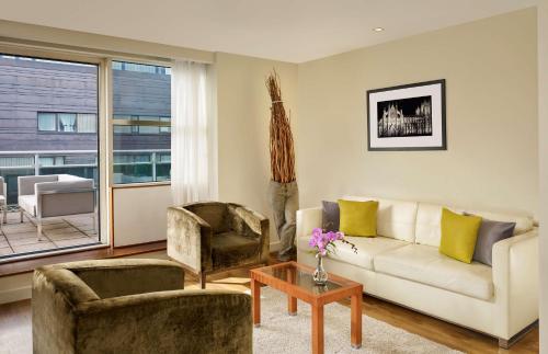 a living room with a couch and two chairs at Park Plaza Victoria London in London