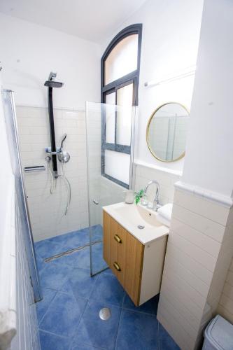 a bathroom with a sink and a shower with a mirror at Suite Sod HaChaim- Artist Quarter Old City Tzfat in Safed