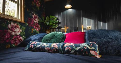 a bed with colorful pillows on top of it at Church House Hut in Melton Mowbray