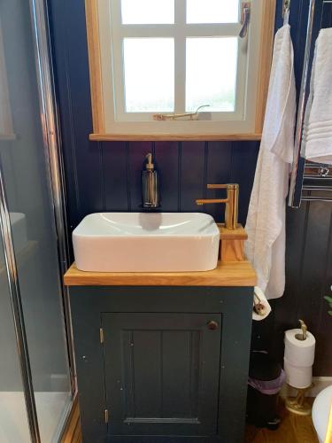a bathroom with a white sink and a window at Church House Hut in Melton Mowbray