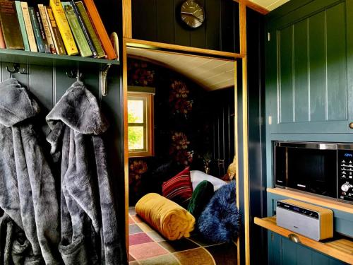a living room with green walls and a mirror at Church House Hut in Melton Mowbray