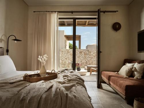 LithakiaにあるPierros Verdeのベッドルーム1室(ベッド1台、ソファ、窓付)