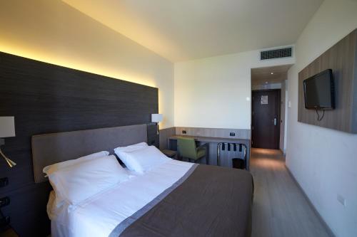 a hotel room with a bed and a television at Hotel Giardino in Arona