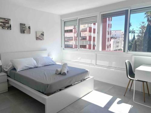 - une chambre avec un lit avec un animal rembourré dans l'établissement Apartamento cerca de la playa, Torre Del Mar, à Torre del Mar