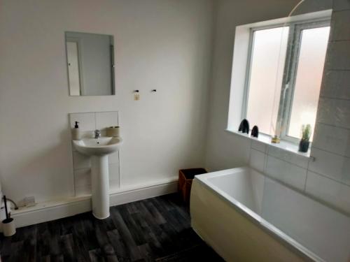 ein Badezimmer mit einem Waschbecken, einer Badewanne und einem Waschbecken in der Unterkunft Wentworth Road Accomodation in Doncaster