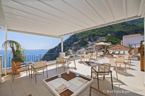 a restaurant with tables and chairs and a view of the ocean at Hotel Punta Regina in Positano