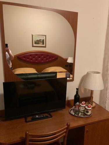 a television sitting on a desk with a mirror at Hotel Banatium B&B Cucina in Tezze sul Brenta