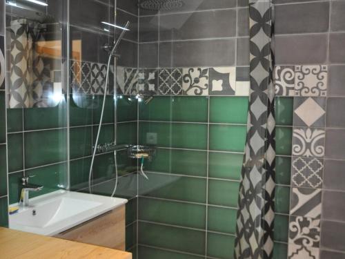 a green tiled bathroom with a sink and a mirror at Appartement La Chapelle-d'Abondance, 3 pièces, 4 personnes - FR-1-692-3 in La Chapelle-dʼAbondance