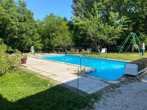 a swimming pool in a yard with a swing at Le Paradis de Clarisse in Trets