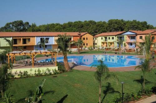 a resort with a large swimming pool in a yard at Case Vacanza Villaggio Riva Azzurra in Policoro