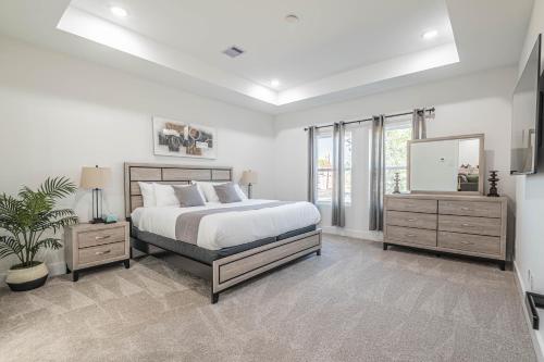 a bedroom with a bed and two dressers and a mirror at New! Houston Luxury Haven near Dwtn, Med CTR in Houston