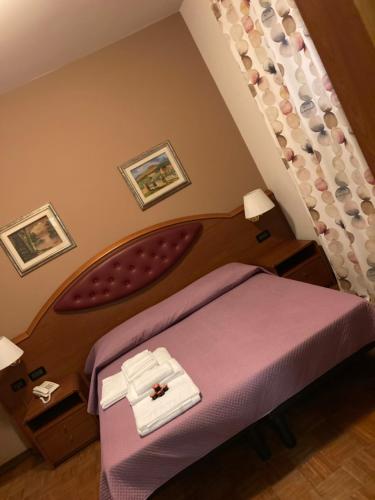 a bedroom with a purple bed in a room at Hotel Banatium B&B Cucina in Tezze sul Brenta