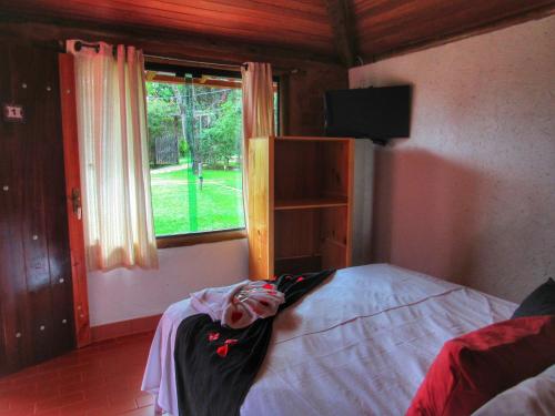 a bedroom with a bed and a window at Pousada Mandalla in Serra do Cipo