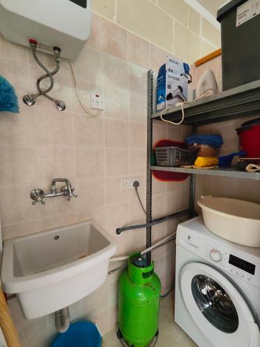 a small kitchen with a sink and a washing machine at Seaview Apartment in Żebbuġ