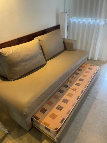 1 cama futón en una sala de estar con en Linda Bay spa playa Unidad 603 Mar de Las Pampas, en Mar de las Pampas