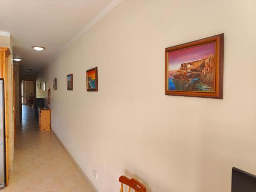 a hallway with a painting on a white wall at Seaview Apartment in Żebbuġ