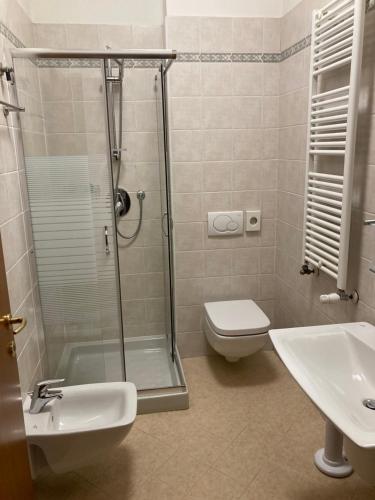 a bathroom with a shower and a toilet and a sink at Hotel Banatium B&B Cucina in Tezze sul Brenta