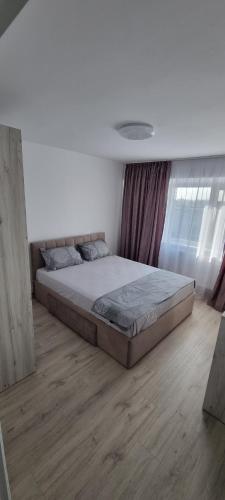 a large bed in a bedroom with a wooden floor at ELIAS LUXURY HOME in Constanţa