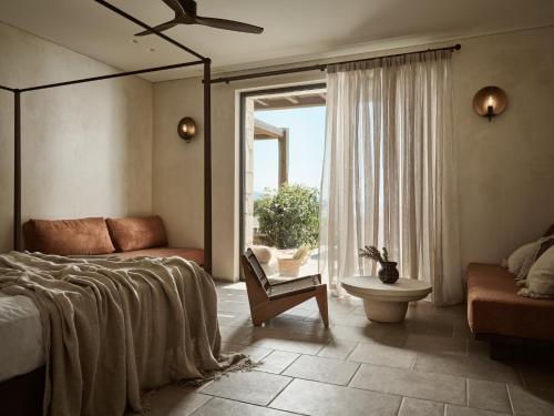 a bedroom with a bed and a couch and a window at Pierros Verde in Lithakia