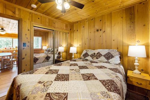 a bedroom with a bed in a room with wooden walls at Cozy Seclusion in South Lake Tahoe