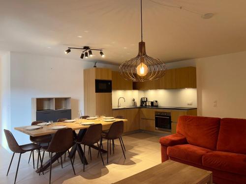 - une cuisine et une salle à manger avec une table et un canapé dans l'établissement Appartement de Standing 6 Pers. - Résidence Neuve Centre des Gets với Garage et Balcon - FR-1-623-328, aux Gets
