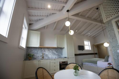 a kitchen with white cabinets and a table and chairs at Trovador Guest House in Guimarães
